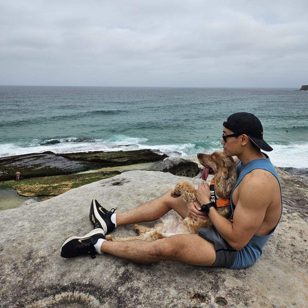 dog and human sitting and looking at the sea
